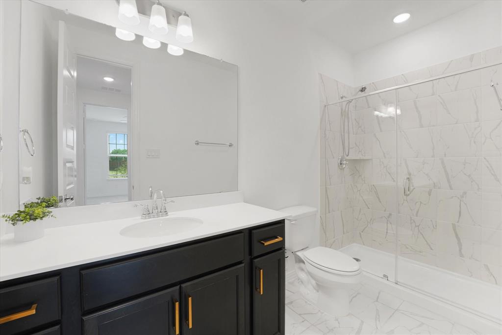 3533 Hyacinth Way Prosper, TX 75078 - Photo 7 of 38 a bathroom with a sink a toilet a mirror and shower