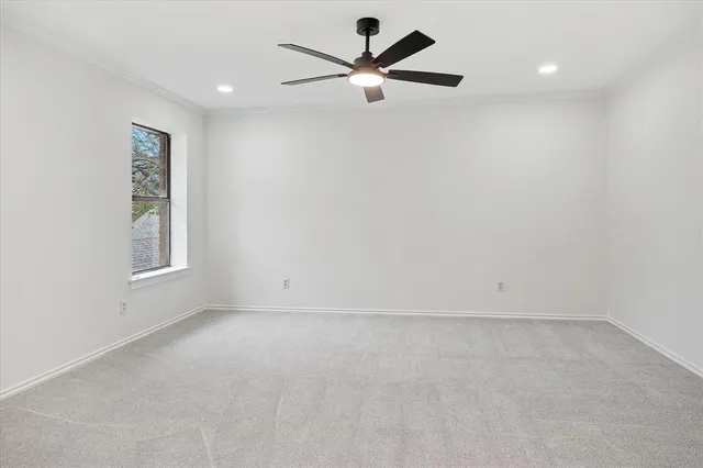 an empty room with a window and a ceiling fan