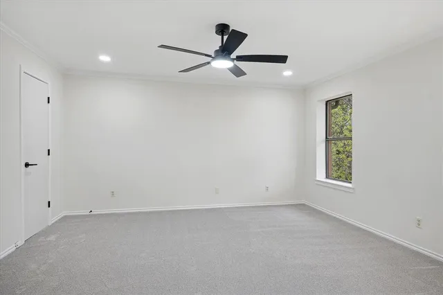 an empty room with ceiling fan and window
