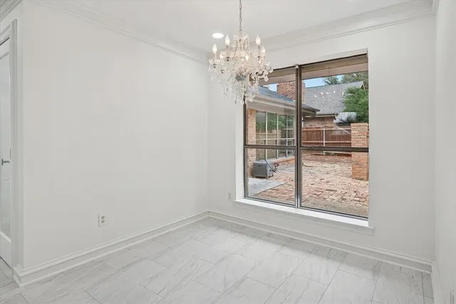 a view of a room that has a large window and chandelier