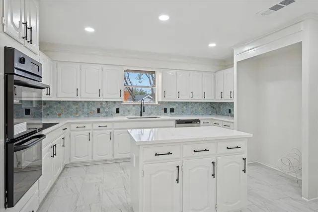 a kitchen with stainless steel appliances granite countertop a sink and dishwasher a stove top oven with white cabinets