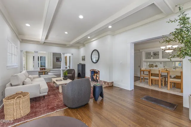 a dining room with wooden floor and a chandelier