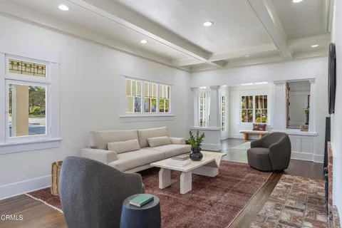 a living room with furniture a rug and a wall painting