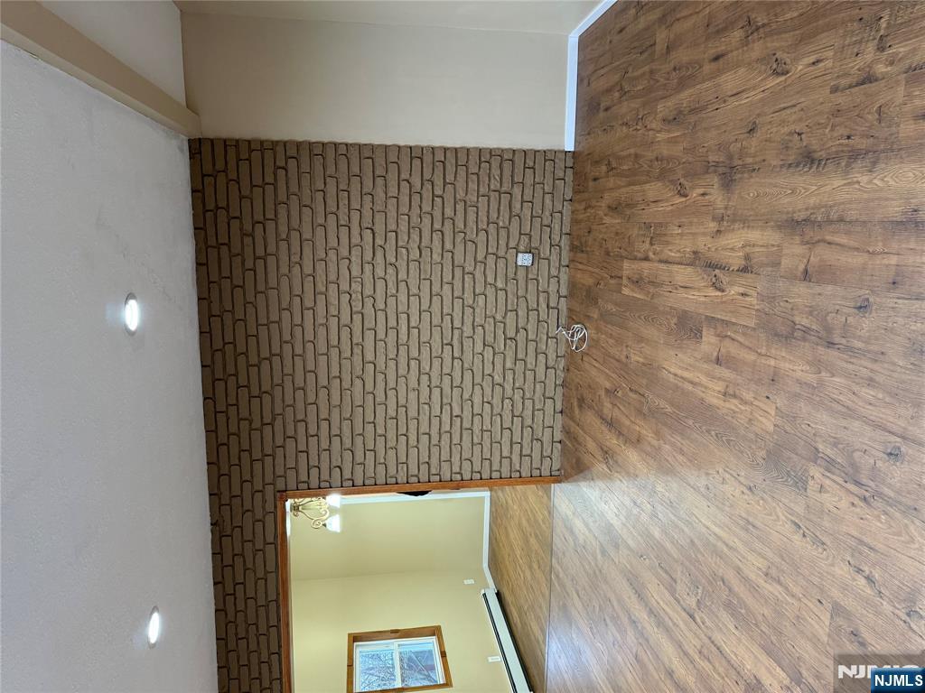 439 Cliff Street, Unit 1 Fairview, NJ 07022 - Photo 2 of 19 an empty room with wooden floor and windows
