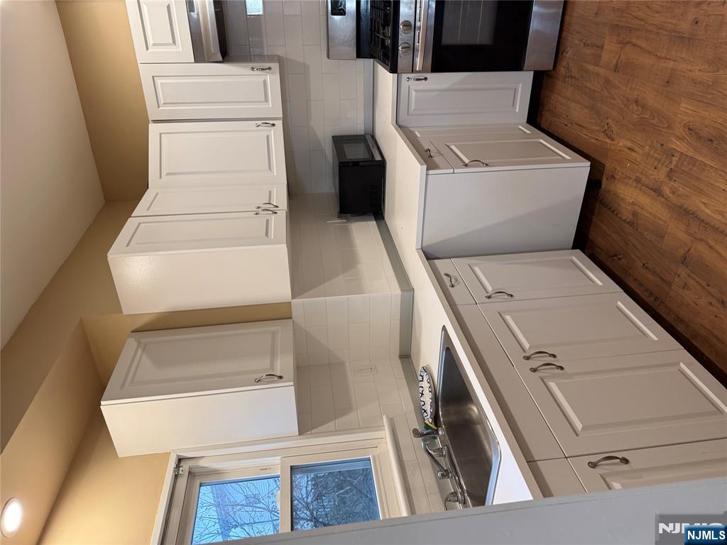 439 Cliff Street, Unit 1 Fairview, NJ 07022 - Photo 5 of 19 a kitchen with white cabinets and white appliances