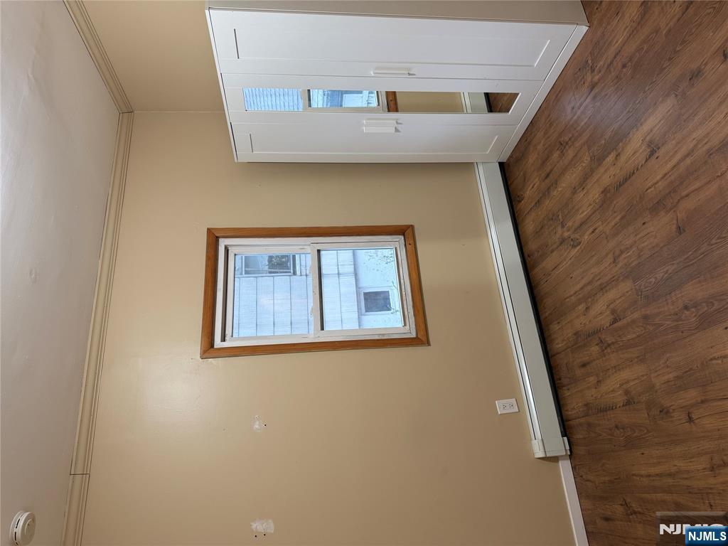 439 Cliff Street, Unit 1 Fairview, NJ 07022 - Photo 10 of 19 an empty room with wooden floor and windows