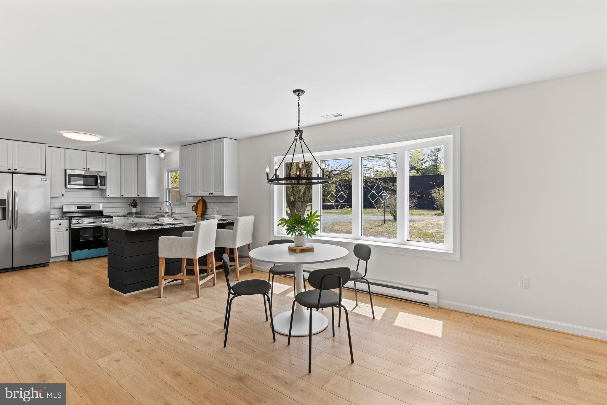 6749 Eldorado Road Federalsburg, MD 21632 - Photo 12 of 39 a kitchen with stainless steel appliances kitchen island granite countertop a dining table chairs and granite counter tops