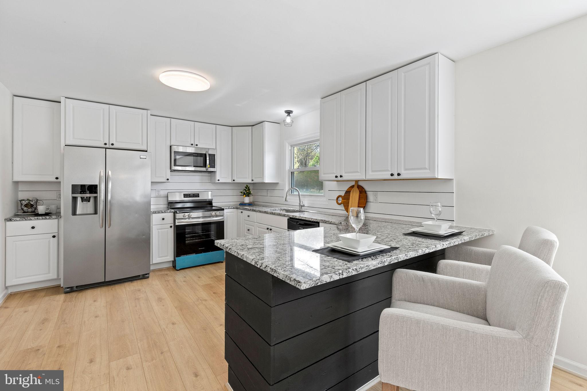 6749 Eldorado Road Federalsburg, MD 21632 - Photo 13 of 39 a kitchen with stainless steel appliances granite countertop a sink refrigerator and cabinets