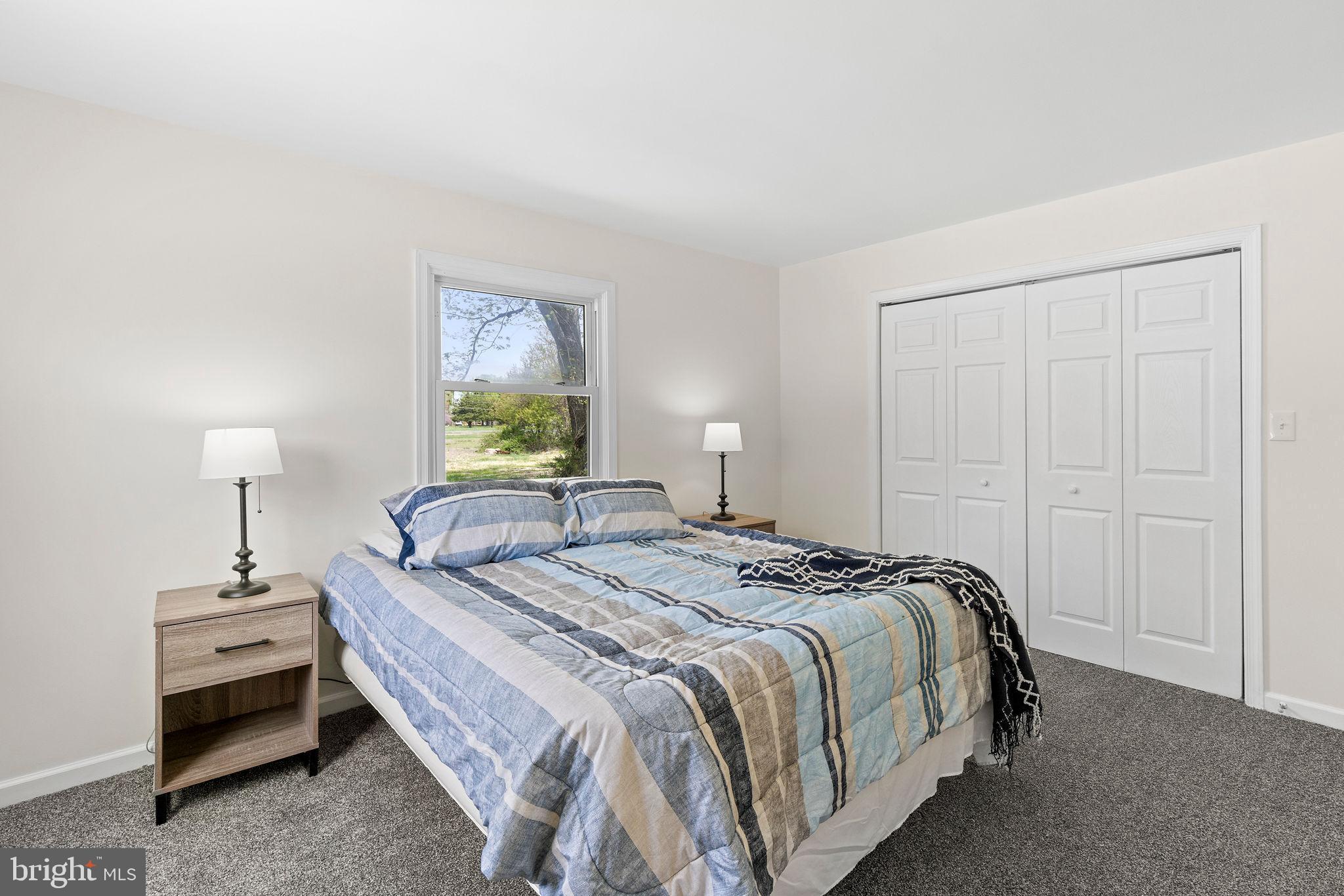 6749 Eldorado Road Federalsburg, MD 21632 - Photo 15 of 39 a bedroom with a bed and a lamp on table