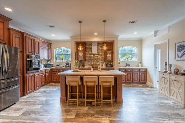 a large kitchen with kitchen island granite countertop a large center island and stainless steel appliances