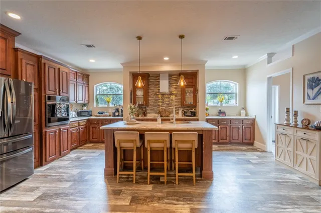 a large kitchen with kitchen island granite countertop a large center island and stainless steel appliances