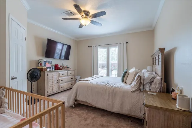 a bedroom with a bed and a flat tv screen on dresser
