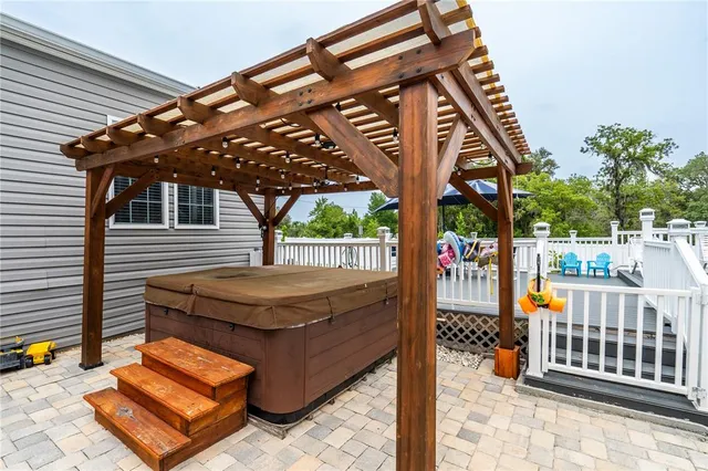 a view of a patio with table and chairs under an umbrella with a small yard