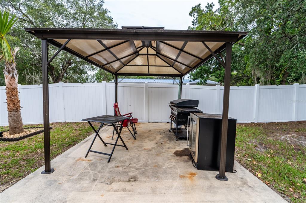 1508 East Winnetka Street Hernando, FL 34442 - Photo 39 of 55 a view of a patio with table and chairs under an umbrella with a small yard