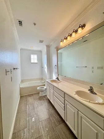 a spacious bathroom with a tub sink and mirror