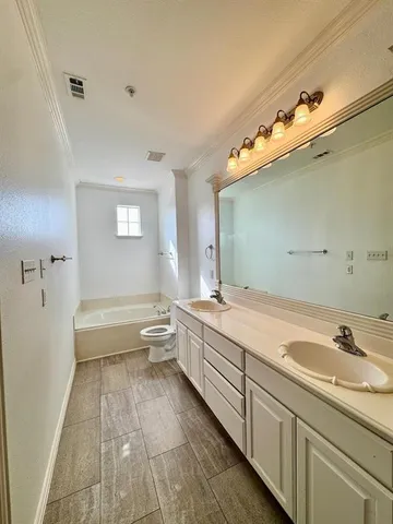 a spacious bathroom with a tub sink and mirror