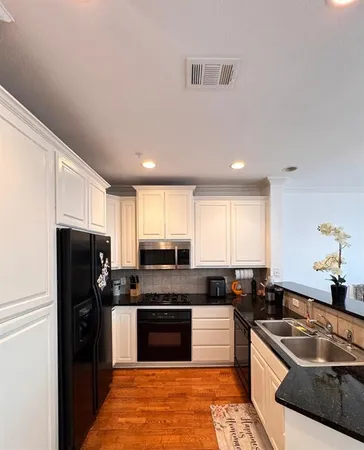 a kitchen with granite countertop a refrigerator and a sink