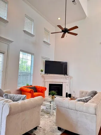a living room with furniture a fireplace and a flat screen tv