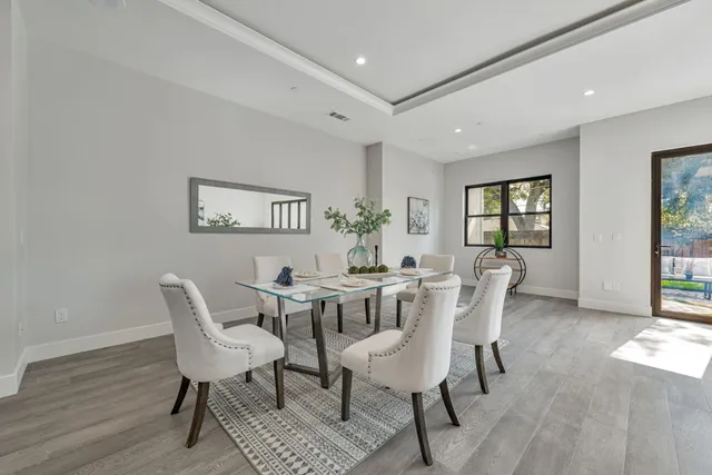 a kitchen with a sink stove and white cabinets with wooden floor