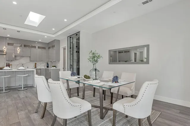 a kitchen with a sink dishwasher and white cabinets with wooden floor