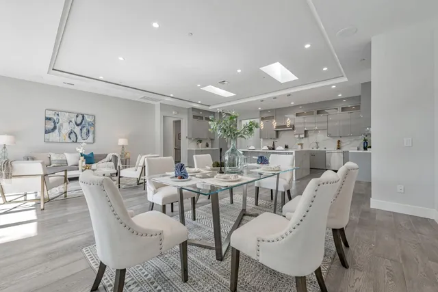a view of dining room and livingroom with furniture wooden floor a chandelier