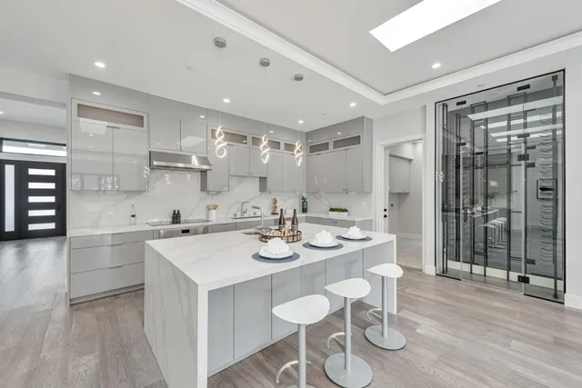 a large kitchen with stainless steel appliances granite countertop a stove a sink and a refrigerator