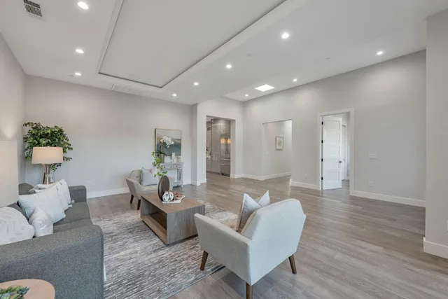 a living room with furniture flowerpot and wooden floor