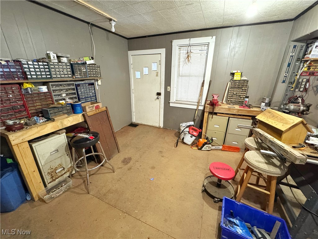 72117 Barton Road Bridgeport, OH 43912 - Photo 23 of 42 Misc room featuring a workshop area, wood walls, and concrete floors