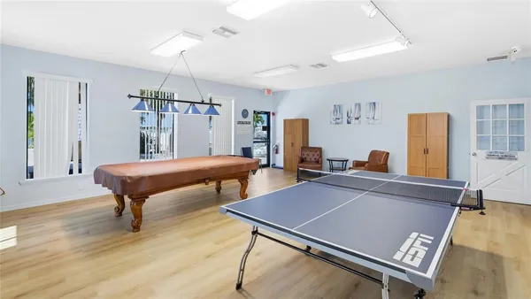 a room with furniture pool table and windows