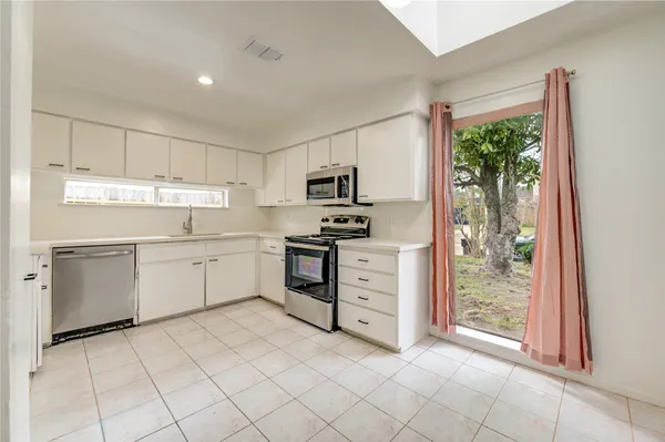 a kitchen with granite countertop a stove top oven microwave and cabinets