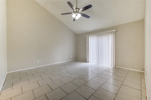 a view of an empty room and window with a fan