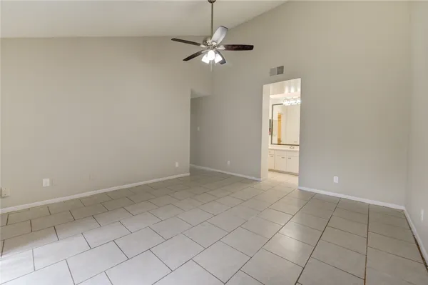 an empty room with windows and fan