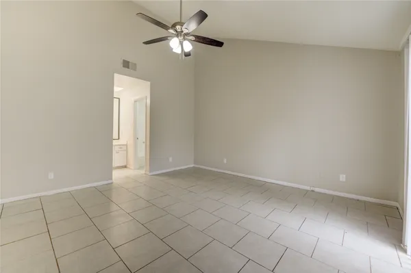 an empty room with a ceiling fan and a window