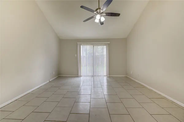 an empty room with a ceiling fan and a window