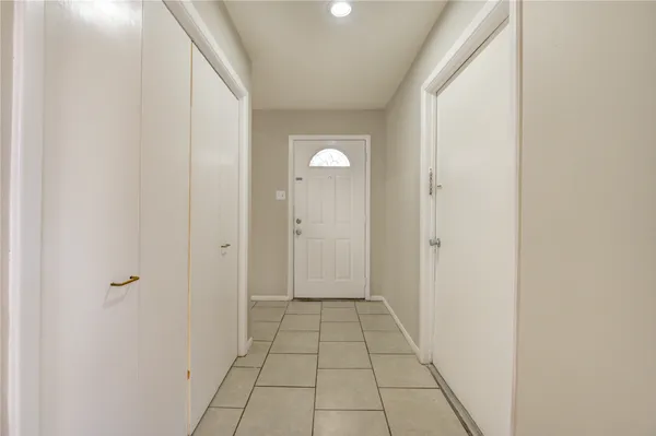 a view of a hallway with wooden floor and a bathroom