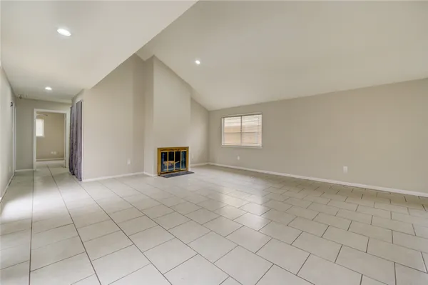 an empty room with windows and fireplace