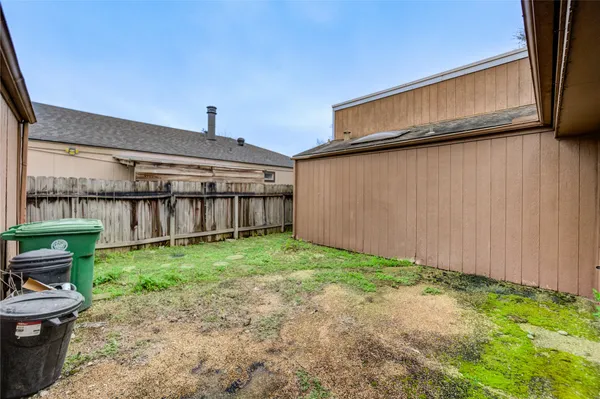 a backyard of a house with wooden fence