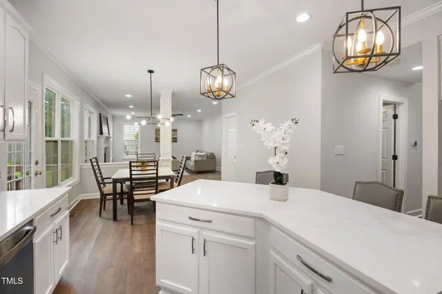 a view of a dining room with furniture a chandelier and wooden floor