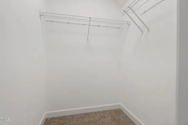 an empty room with a window and a ceiling fan