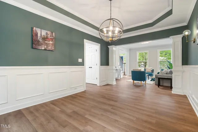 a view of a livingroom with wooden floor and chandelier