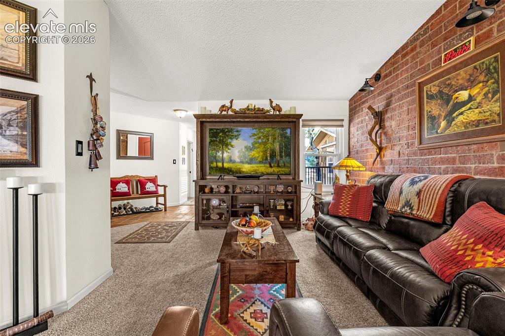 1658 Deer Creek Road Monument, CO 80132 - Photo 5 of 21 Living room with brick accent wall -