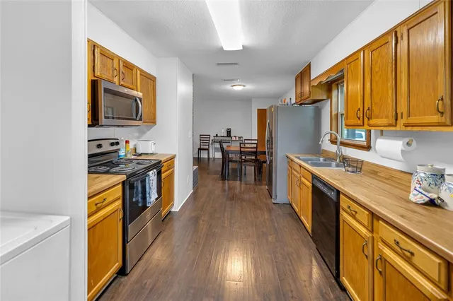 a kitchen with stainless steel appliances granite countertop lots of counter top space and wooden floor