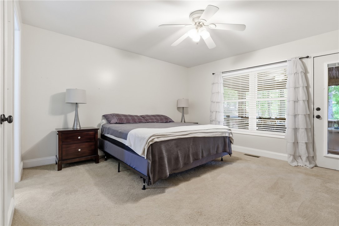 1110 Sunset Lane Anderson, SC 29626 - Photo 11 of 38 A comfortable bedroom features carpet flooring and a ceiling fan, with natural light entering through a large window.