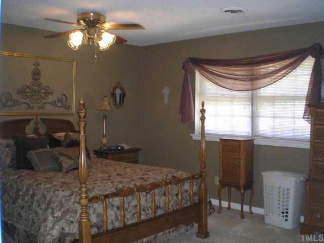 1606 Medfield Road Raleigh, NC 27607 - Photo 4 of 10 a bedroom with a bed and a chandelier