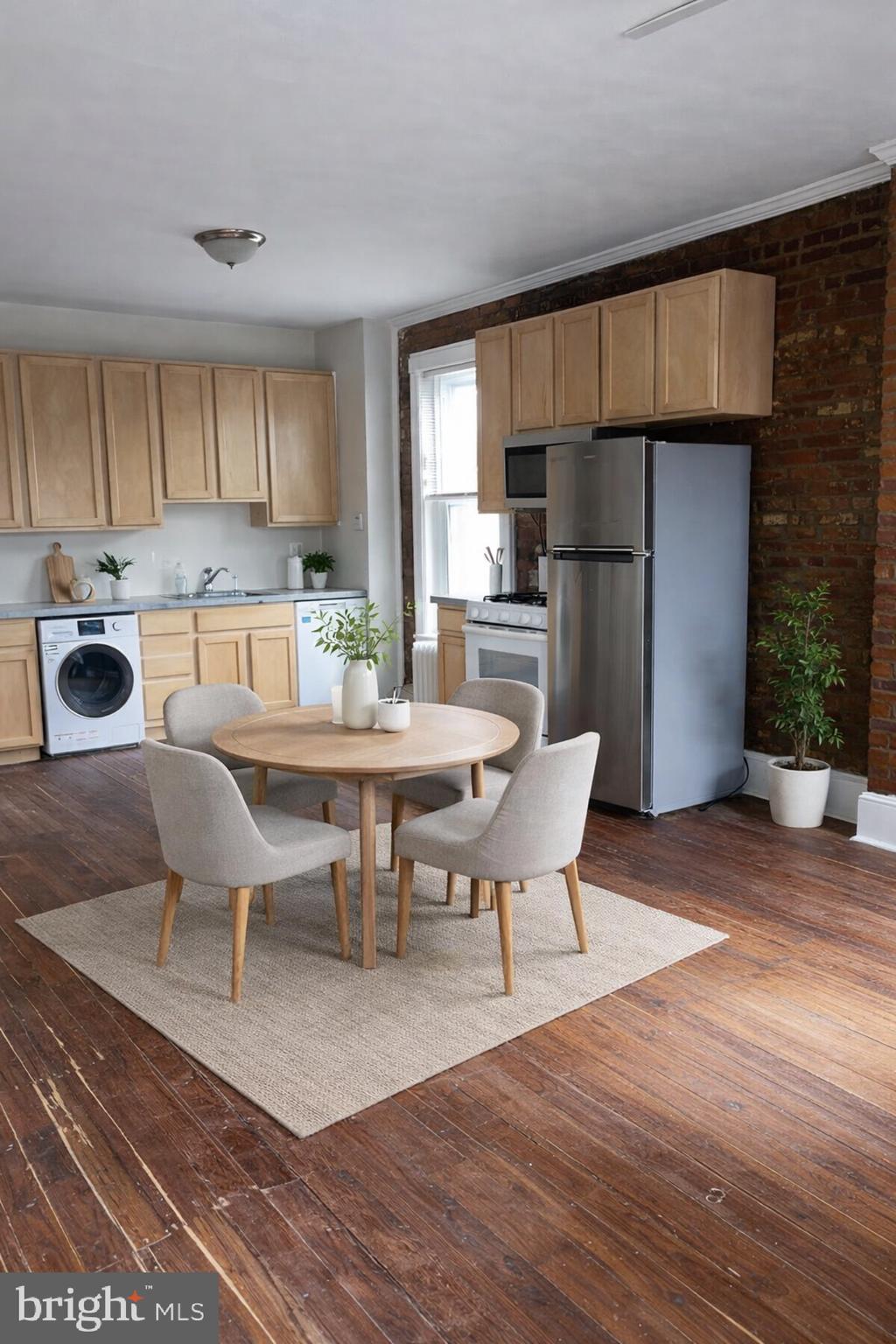 7611 Ridge Avenue, Unit 2 Philadelphia, PA 19128 - Photo 4 of 16 a kitchen with a dining table chairs refrigerator and cabinets