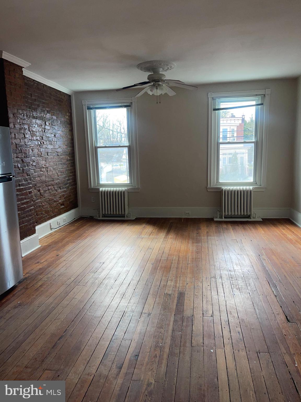 7611 Ridge Avenue, Unit 2 Philadelphia, PA 19128 - Photo 5 of 16 an empty room with wooden floor and windows
