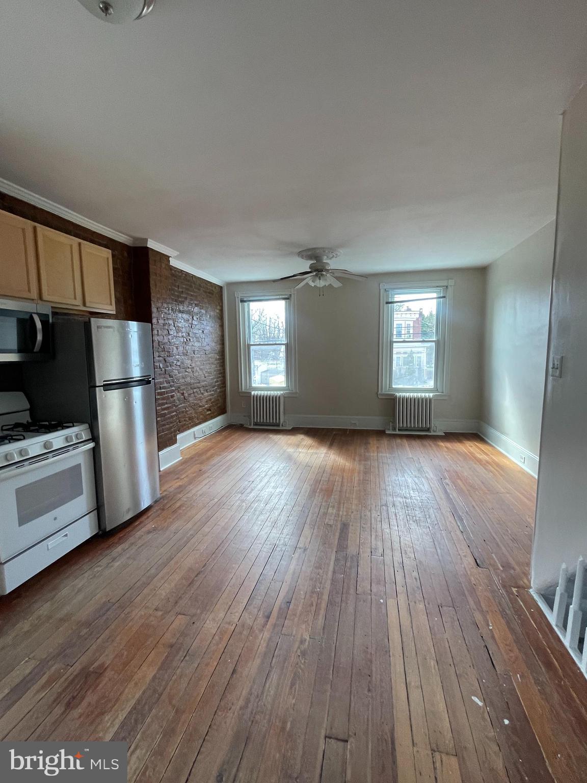 7611 Ridge Avenue, Unit 2 Philadelphia, PA 19128 - Photo 6 of 16 a view of a livingroom with wooden floor and a kitchen space