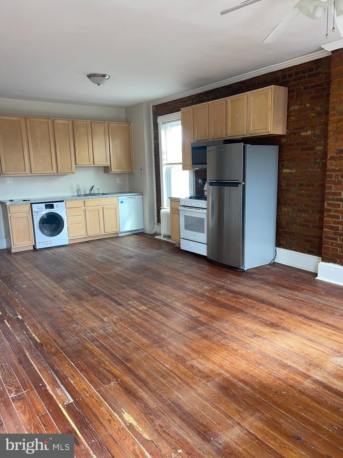 7611 Ridge Avenue, Unit 2 Philadelphia, PA 19128 - Photo 7 of 16 a kitchen with stainless steel appliances wooden cabinets a sink and a refrigerator