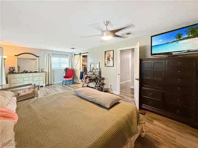 a bedroom with a bed and a dresser with mirror