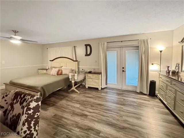 a bedroom with a bed and a large mirror on the dresser